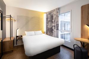 尼斯B&B HOTEL Nice Aéroport Arenas的酒店客房设有一张白色大床和一个窗户。