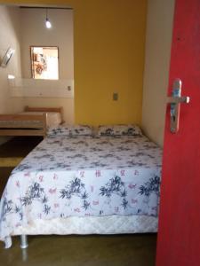 伦索伊斯Casa Repousar的一间卧室配有一张带蓝色和白色棉被的床