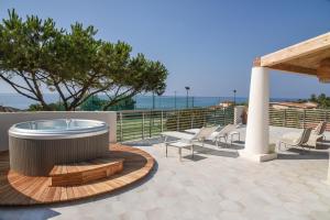 梵蒂冈角Baia Del Sole Resort的一个带热水浴缸和躺椅的庭院