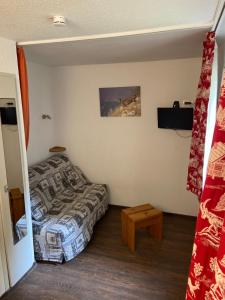 里蒙纽耶Appartement Les Menuires的小房间设有床、床和桌子