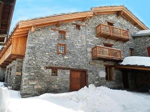 Val CenisChalet Alpin的一座石头建筑,上面设有木制阳台