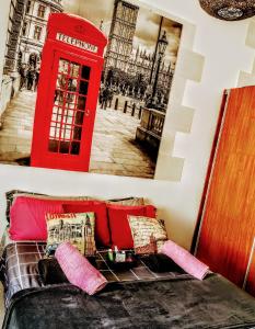 圣克鲁斯-德特内里费Casapatrizia Appartamento compartido的一间设有红色电话亭和沙发的房间