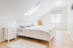 哈普萨卢Wiigi Apartments的白色的卧室设有白色的床和窗户。