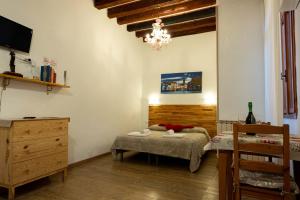 威尼斯Ca' del Megio的一间卧室配有一张床、梳妆台和吊灯。