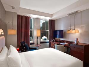 达拉斯焦耳酒店的酒店客房设有一张大床和一张书桌。