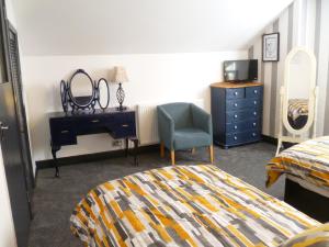 基德明斯特Charming Spacious Apartment, Kidderminster的一间卧室配有一张床、一张桌子和一把椅子