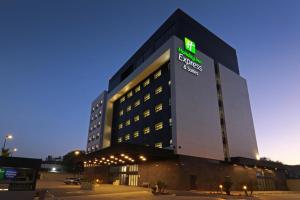 恩塞纳达港Holiday Inn Express & Suites - Ensenada Centro, an IHG Hotel的一座大建筑,上面有灯光标志