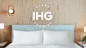 恩塞纳达港Holiday Inn Express & Suites - Ensenada Centro, an IHG Hotel的床上方标牌,带两个枕头