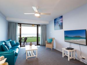 士兵点Harbourside 4 ground floor on the waterfront的客厅配有蓝色的沙发和电视