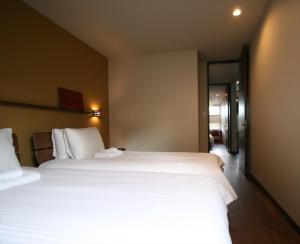 富良野MOKUREN的一间酒店客房,设有两张床和走廊