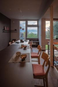 富良野MOKUREN的厨房配有长桌子、椅子和窗户