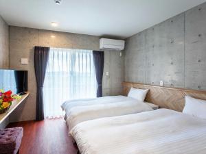 名户Little Island Okinawa Nago的酒店客房设有两张床和窗户。