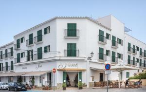 埃斯·梅卡达尔Hotel Jeni & Restaurant的一座白色的大建筑,设有绿色百叶窗
