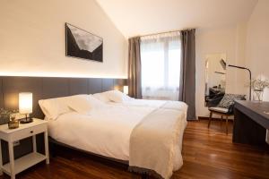 奥尼亚特Soraluze Hotela的卧室设有一张白色大床和一扇窗户。