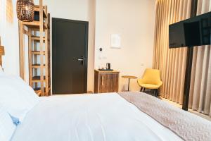 米茨佩·拉蒙Even Derech by Smart Hotels的一间卧室配有一张床、一台电视和一把椅子