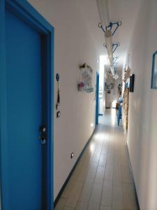 玛格丽塔萨沃亚ControVento Rooms的走廊设有蓝色门,铺有瓷砖地板