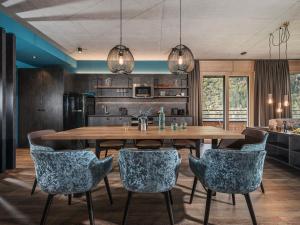 迈尔霍芬Sieghard Suites Mayrhofen的厨房以及带木桌和椅子的用餐室。