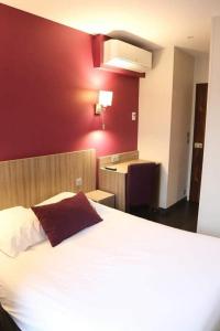 拉沙特尔HOTEL DU COMMERCE的卧室配有白色的床和红色的墙壁