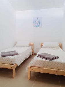 FicarazziVILLA MOGUNTIA的两张睡床彼此相邻,位于一个房间里