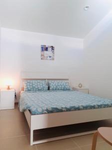 FicarazziVILLA MOGUNTIA的一间卧室配有一张带蓝色棉被的床