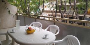 萨洛SCALA Apartaments的阳台上的白色桌子和一碗水果