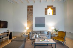 卡塞雷斯阿雷纳莱斯宫殿霍斯皮斯及spa酒店的客厅配有沙发和桌子