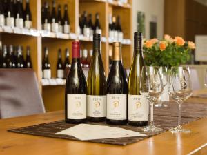 Flörsheim-DalsheimGästehaus & Weingut PETH的四瓶葡萄酒和酒杯坐在桌子上