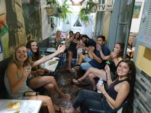 雅典帕格瑞什青年旅舍的一群人坐在酒吧里,戴着酒杯