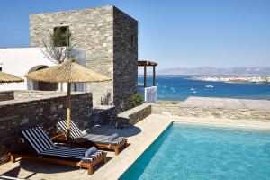 KolympithresAcron Villas Paros的别墅 - 带游泳池、2把椅子和遮阳伞