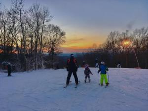 东斯特劳兹堡肖尼酒店和高尔夫度假村的一群人,在日落时分在雪地里滑雪