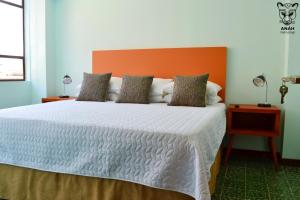 危地马拉Apartamentos el Prado en Zona 1 - ANAH hotel group的一间卧室配有一张带橙色床头板的大床