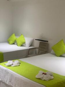 卡塔赫纳HOTEL CASA GARCES的一间设有两张床铺和毛巾的房间