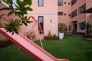 危地马拉Apartamentos el Prado en Zona 1 - ANAH hotel group的院子中间的粉红色滑梯
