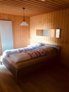 芙露姆赛山Casa Alpetta的卧室配有木墙内的一张床