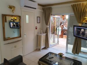埃拉特Thai villa eilat - וילה תאי אילת的客厅配有桌子、镜子和电视