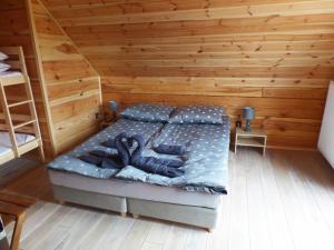 SygontkaChata Sosenka的木制客房内的一间卧室,配有一张床