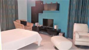 蓝海湾Villa De Rouba的客厅配有床、电视和椅子