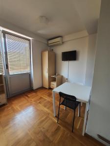 乌日策Apartman Panorama 3 Glavna ulica的小房间设有白色桌子和椅子