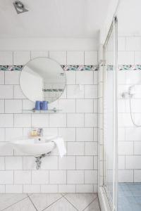 柏林City Hotel Ansbach am KaDeWe的白色的浴室设有水槽和镜子