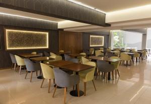 门多萨城市级别酒店的用餐室配有木桌和椅子