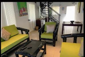 Brufut冈比亚西比斯科斯旅馆的客厅配有两把椅子和一张茶几