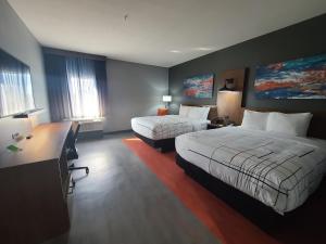 斯托克顿堡La Quinta Inn & Suites by Wyndham Fort Stockton Northeast的酒店客房配有两张床和一张书桌