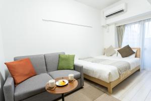 东京千鸟町时尚公寓的客厅配有沙发和1张床