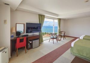 名户冲绳余家弗酒店的酒店客房配有一张床和一张书桌及一台电视
