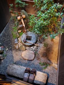 京都Machiya Kaemon的一座小型花园,地面上放着两双鞋