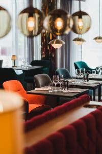 斯德哥尔摩里瓦尔酒店的餐厅设有桌椅和玻璃杯