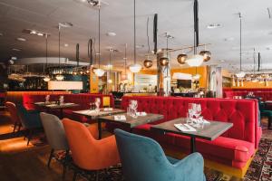 斯德哥尔摩里瓦尔酒店的餐厅设有红色的沙发和桌椅