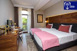 第比利斯第比利斯宫殿酒店的酒店客房设有两张床、一张桌子和一台电视。