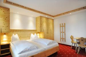 蒂罗尔州奥伯恩多夫基茨比厄尔阿尔卑斯山国王酒店的卧室配有一张白色的大床和一张桌子