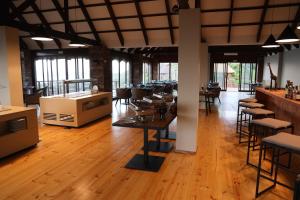 马普托Montebelo Milibangalala Bay Resort的餐厅铺有木地板,配有桌椅